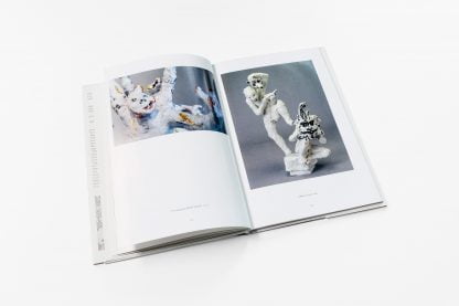Otwarta książka z fotografiami białych rzeźb na obu stronach.