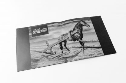 Czarno-biała fotografia konia ciągnącego drewniany krzyż. Napis Catolic-Cola.