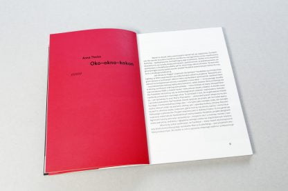 Otwarta książka, po lewej czerwona strona z czarnym napisem Oko-okno-kokon, Po prawej biała z czarnym tekstem.