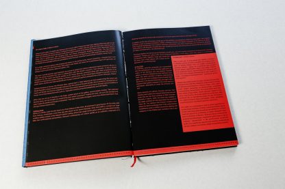 Otwarta książka, na czarnych stronach czerwony tekst.