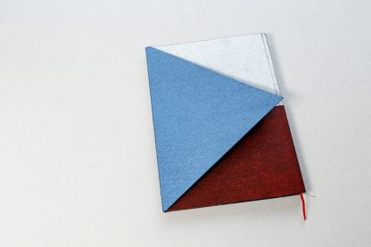 Biało-czerwona okładka książki z niebieskim trójkątem.